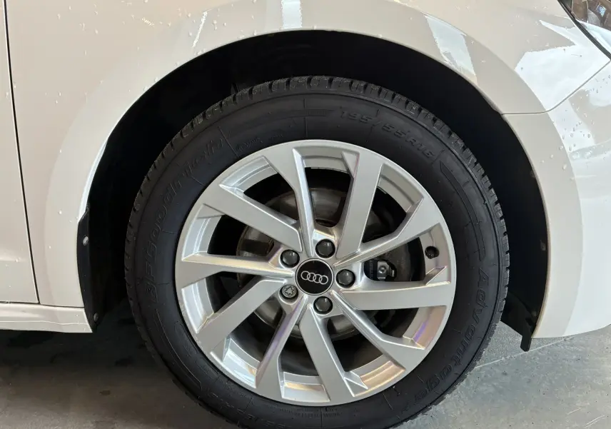 Gros plan sur la jante alu 17 pouces argentée et le pneu BFGoodrich d'une Audi A1 blanche, côté avant droit.