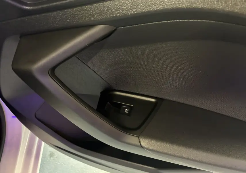 Gros plan sur la commande de lève-vitre côté conducteur de l'Audi A1 blanche, intérieur noir.