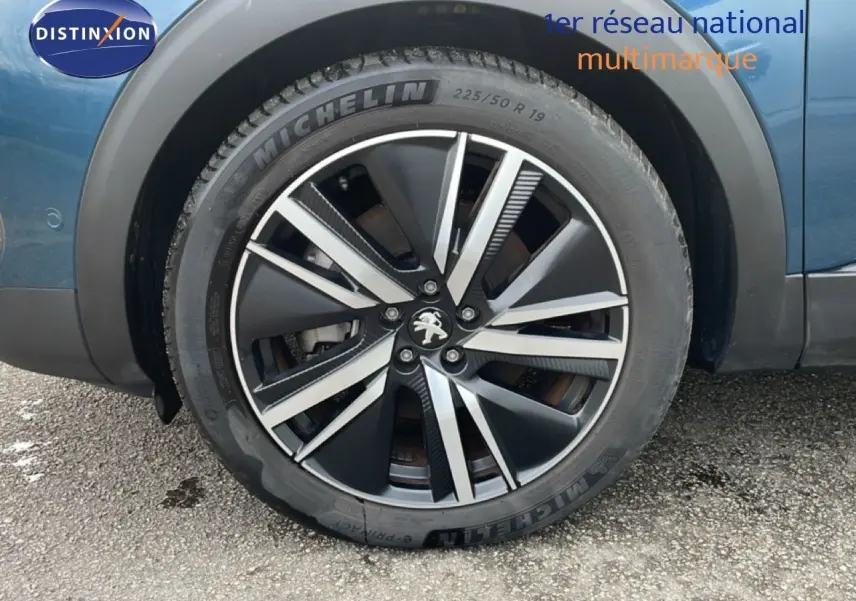 Gros plan sur la roue avant droite d’un Peugeot 3008 bleu Célèbes Métal avec jante alliage noire et argent.