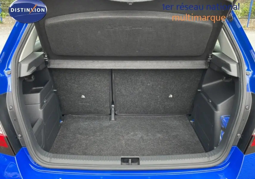 Coffre ouvert vu de l'arrière d'une Skoda Fabia 1.0 TSI 95CH Active bleu énergie, montrant l'espace de chargement vide.