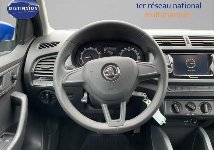 Vue intérieure centrée sur le volant Skoda Fabia bleu énergie, tableau de bord et écran tactile visibles.