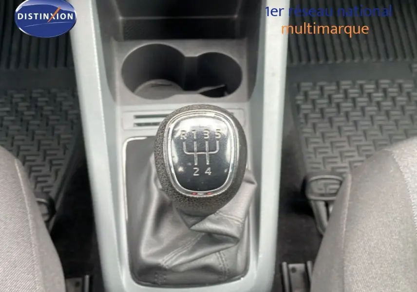 Gros plan sur le levier de vitesses manuel de la Skoda Fabia bleu énergie, avec console centrale et tapis noirs visibles.