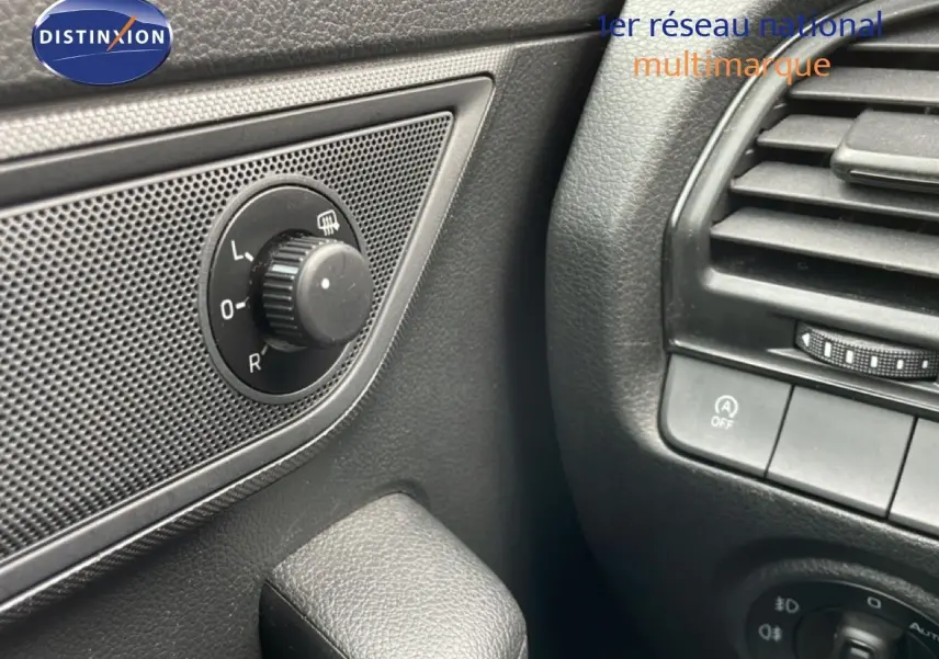 Gros plan sur le réglage des rétroviseurs côté gauche et la ventilation intérieure noire d'une Skoda Fabia bleu énergie.