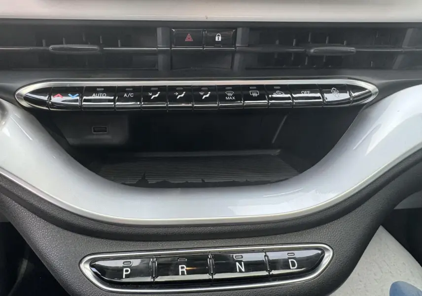 Vue rapprochée de la console centrale blanche de la Fiat 500 électrique 2022, avec commandes climatisation et boîte auto.