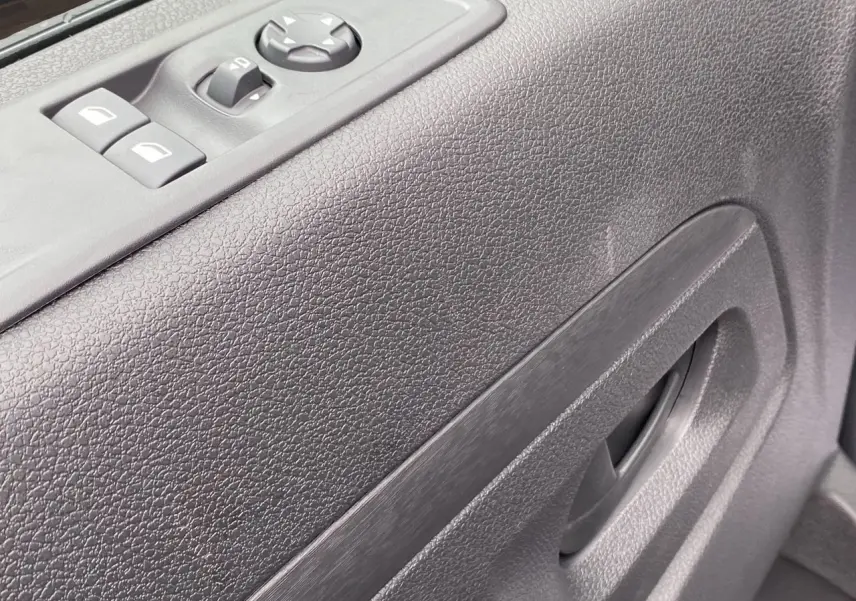 Gros plan sur la porte côté gauche de l’Opel Vivaro noir, montrant les commandes électriques des vitres et le bouton de réglage des rétroviseurs.