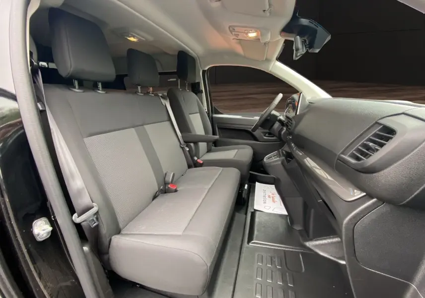 Intérieur de l'Opel Vivaro noir, vue côté gauche sur les sièges avant et tableau de bord moderne.