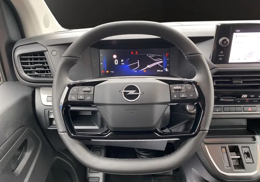 Vue rapprochée du volant noir et du tableau de bord numérique d'un Opel Vivaro 2025 avec commandes intégrées.