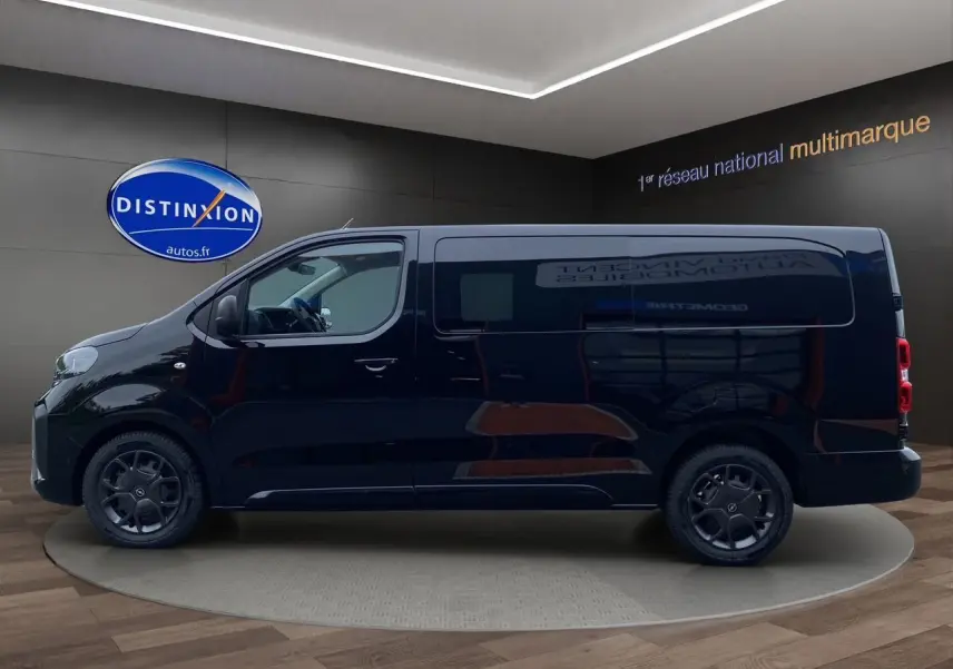 Profil côté gauche d'un Opel Vivaro noir 2025 avec jantes noires et vitres teintées en showroom.