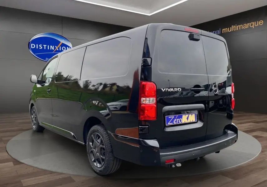 Vue 3/4 arrière droite d’un Opel Vivaro noir 2025 avec attelage et jantes noires en showroom.