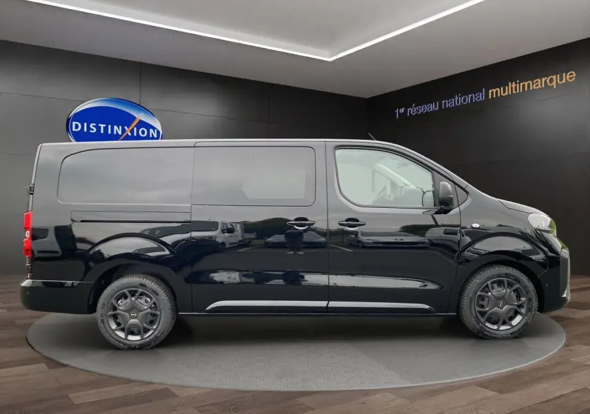 Profil latéral droit d'un Opel Vivaro noir 2025 avec portes coulissantes et jantes acier en showroom.