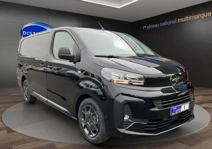 Vue 3/4 avant d'un Opel Vivaro noir 2025 avec attelage et jantes noires dans un showroom.