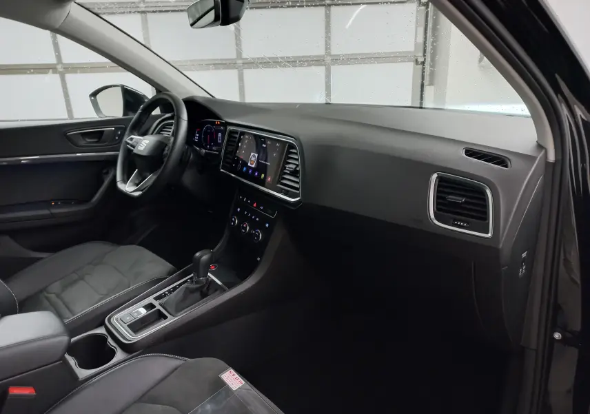 Intérieur côté conducteur du SEAT Ateca 2025 noir, tableau de bord moderne avec écran tactile et volant multifonction.