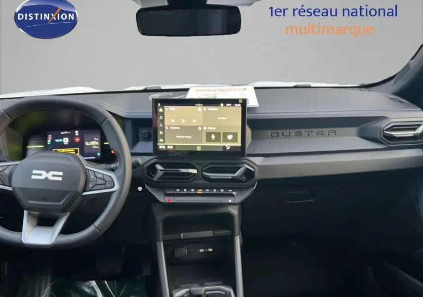 Vue intérieure frontale du tableau de bord du Dacia Duster Hybrid 140 Journey avec écran tactile central et volant multifonction.
