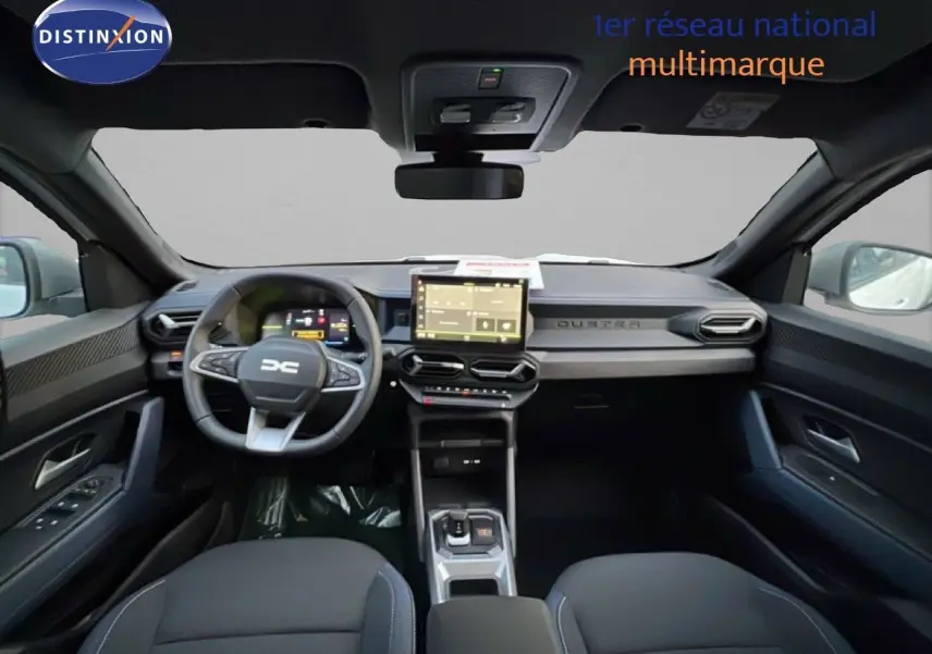 Vue intérieure avant du Dacia Duster Hybrid 140 Journey, tableau de bord moderne avec écran tactile central et volant multifonction.