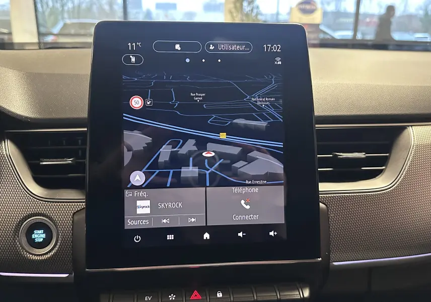 Vue rapprochée de l’écran tactile central du tableau de bord du Renault Arkana noir, affichant la navigation GPS.