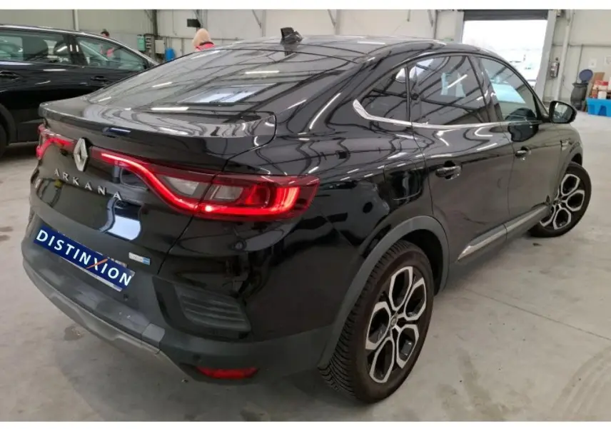 Vue 3/4 arrière droite du Renault Arkana noir 2022 avec feux arrière LED et jantes distinctives en intérieur d'atelier.