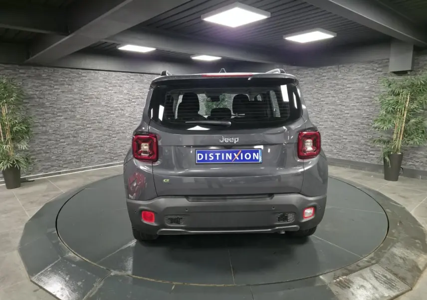 Vue arrière du Jeep Renegade gris métallisé avec toit noir, feux LED et logo distinctif sur un plateau tournant.