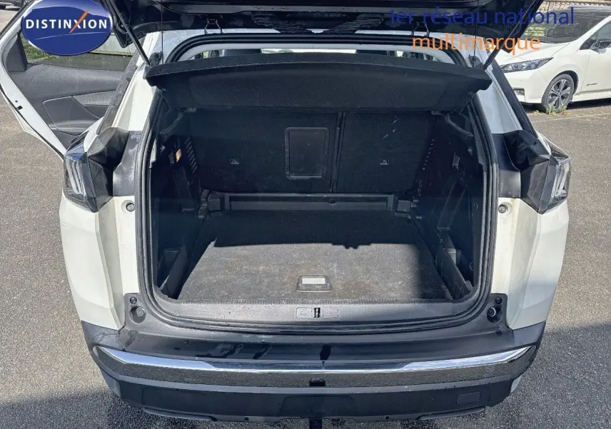 Coffre ouvert vu de l'arrière d'un Peugeot 3008 blanc nacré métal, montrant l'espace de chargement vide.