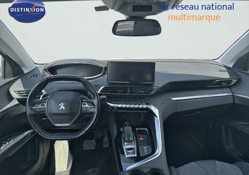 Vue intérieure du tableau de bord et volant du Peugeot 3008 blanc nacré, avec écran central et commandes modernes.