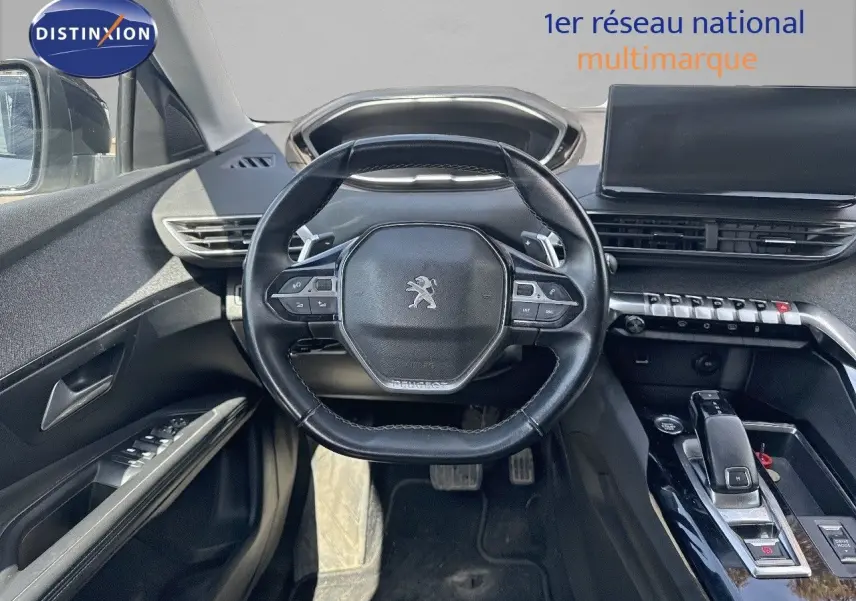 Vue intérieure centrée sur le volant compact et la console centrale noire du Peugeot 3008 blanc nacré 2022.
