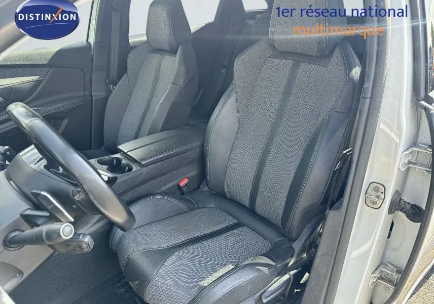 Vue intérieure côté conducteur du Peugeot 3008 blanc nacré, mettant en valeur le siège avant en tissu et cuir noir.