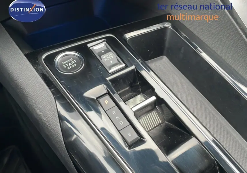 Gros plan sur la console centrale noire brillante du Peugeot 3008 hybride avec boutons start/stop et sélection mode conduite.