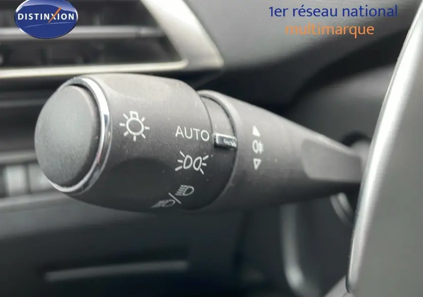 Gros plan sur la commande des feux du Peugeot 3008 gris Artense, intérieur noir, version hybride rechargeable 2024.