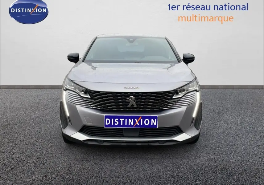 Vue frontale d’un Peugeot 3008 gris Artense métal 2024 avec calandre noire et feux LED verticaux allumés.