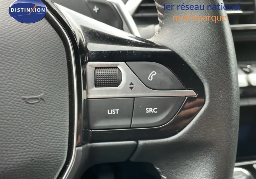 Gros plan sur les commandes gauche du volant cuir noir du Peugeot 3008 hybride rechargeable gris Artense 2024.