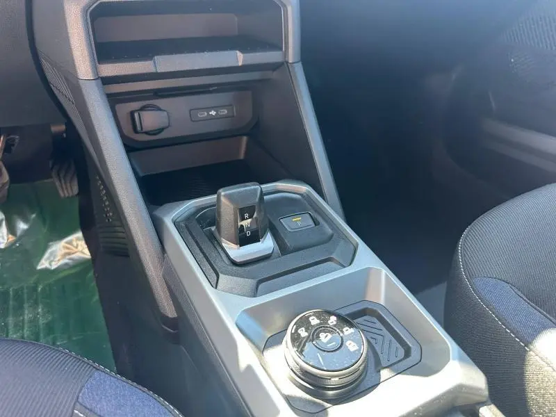 Vue rapprochée de la console centrale du Dacia Duster 2026 avec boîte auto et commande de mode de conduite.