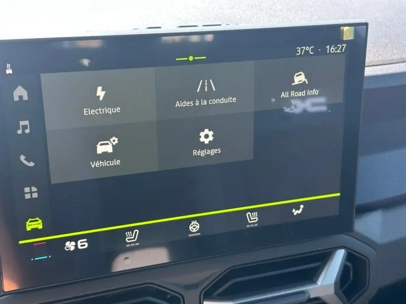 Écran tactile central du tableau de bord du Dacia Duster 2026 affichant les menus d’aides à la conduite et réglages.