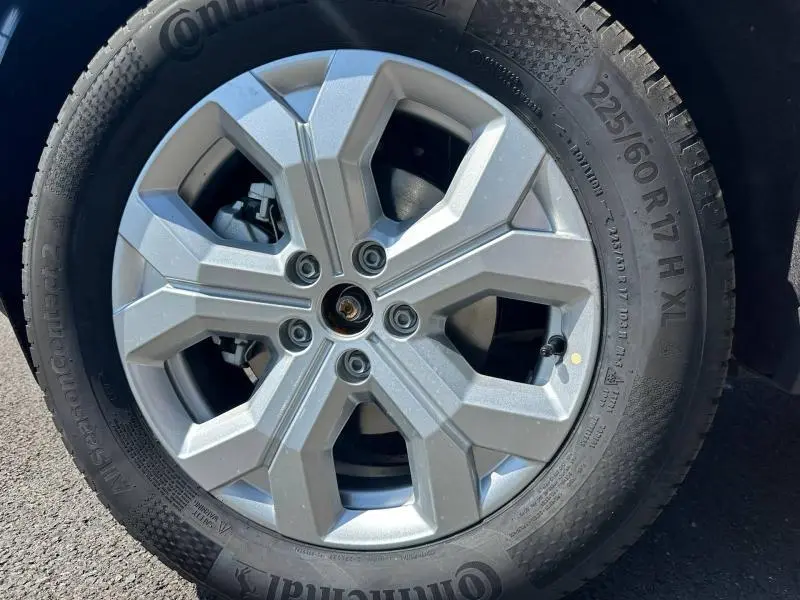Gros plan sur la jante alu argentée et le pneu Continental d’un Dacia Duster Vert Cèdre métallisé.