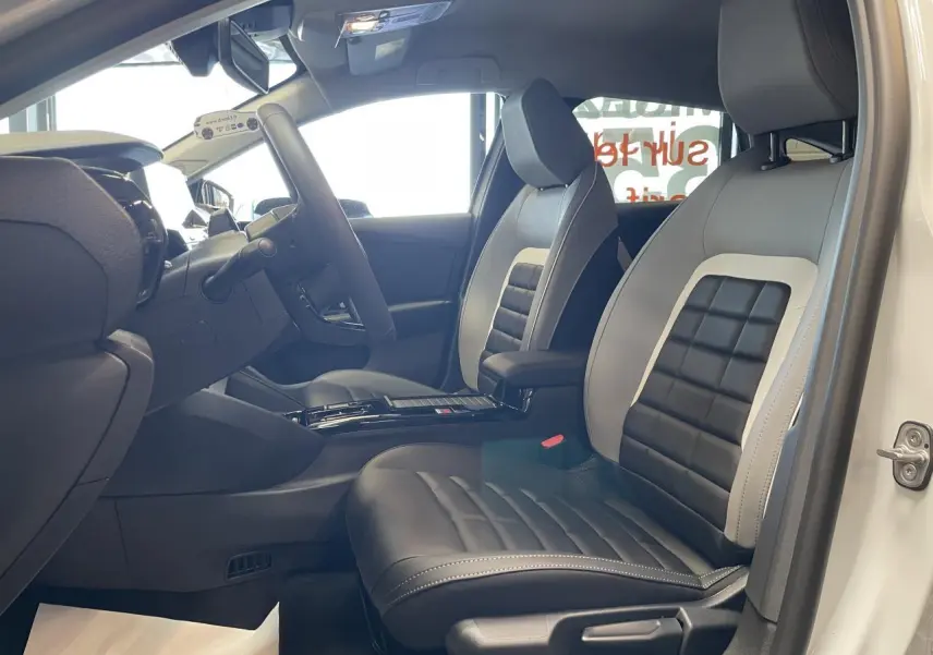 Vue intérieure côté conducteur de la Citroën C4 blanche avec sièges Advanced Comfort bicolores noir et gris clair.