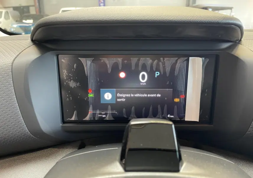 Vue rapprochée du tableau de bord numérique de la Citroën C4 blanche, affichant un message d'arrêt du véhicule.