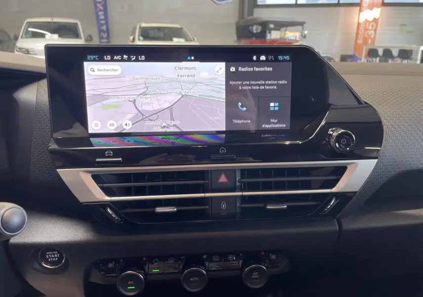 Vue intérieure du tableau de bord de la Citroën C4 blanche, écran tactile central avec navigation et commandes climatisation.