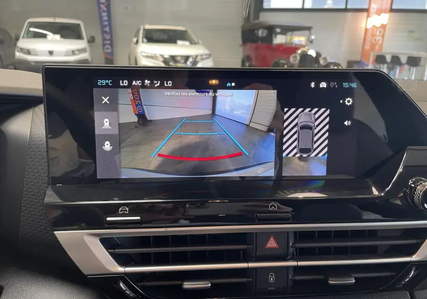 Écran central affichant la caméra de recul d'une Citroën C4 blanche en intérieur de garage.