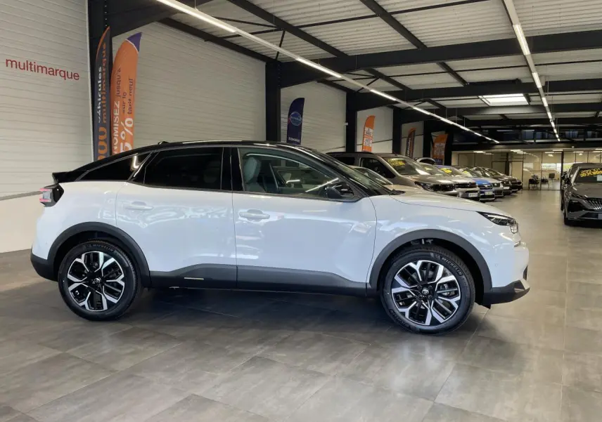 Vue de profil droit d'une Citroën C4 blanche avec toit noir et jantes alliage 18 pouces en concession.