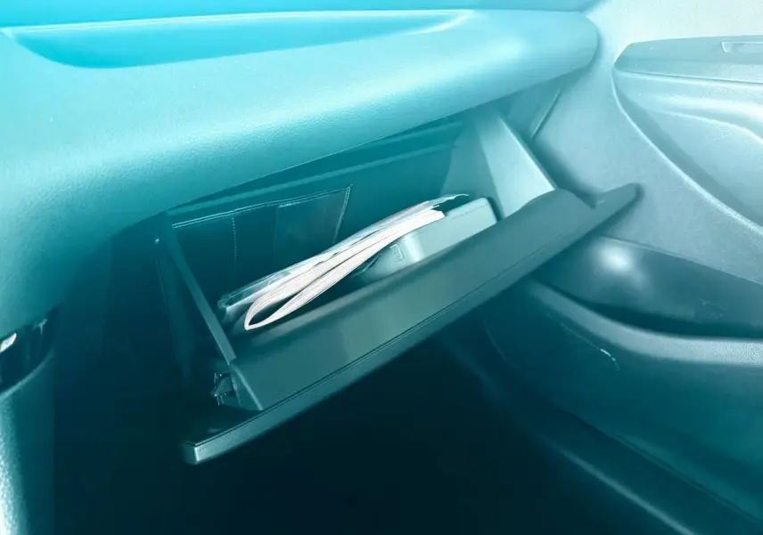 Gant de boîte à gants ouvert avec documents visibles dans l'habitacle d'une Toyota Yaris hybride 2025.