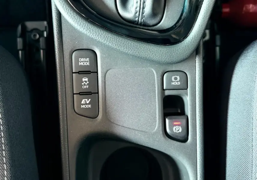 Gros plan sur la console centrale de la Toyota Yaris Hybrid 2025, montrant les boutons Drive Mode, EV Mode et frein de parking électrique.
