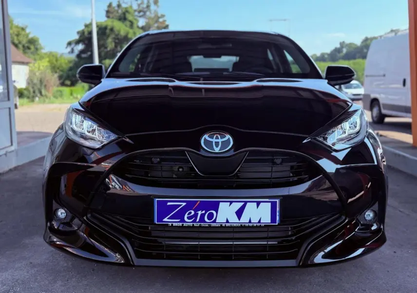 Vue frontale d'une Toyota Yaris Hybrid noire avec calandre large et phares LED distinctifs.