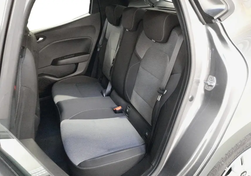 Vue intérieure arrière côté droit de la Renault Clio V E-Tech gris schiste, montrant la banquette arrière en tissu gris à motifs.