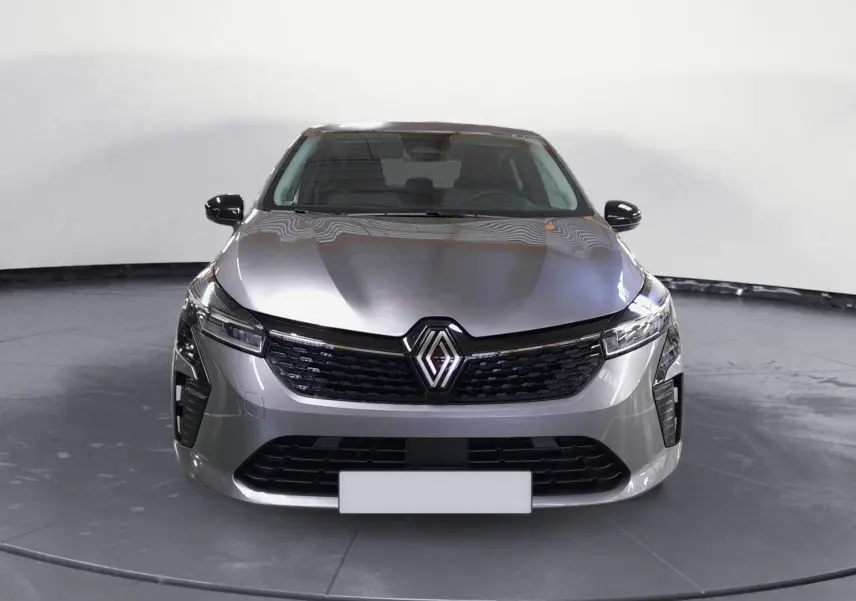 Vue avant d'une Renault Clio V E-Tech Full Hybrid 145 gris schiste avec calandre noire et phares LED allumés.