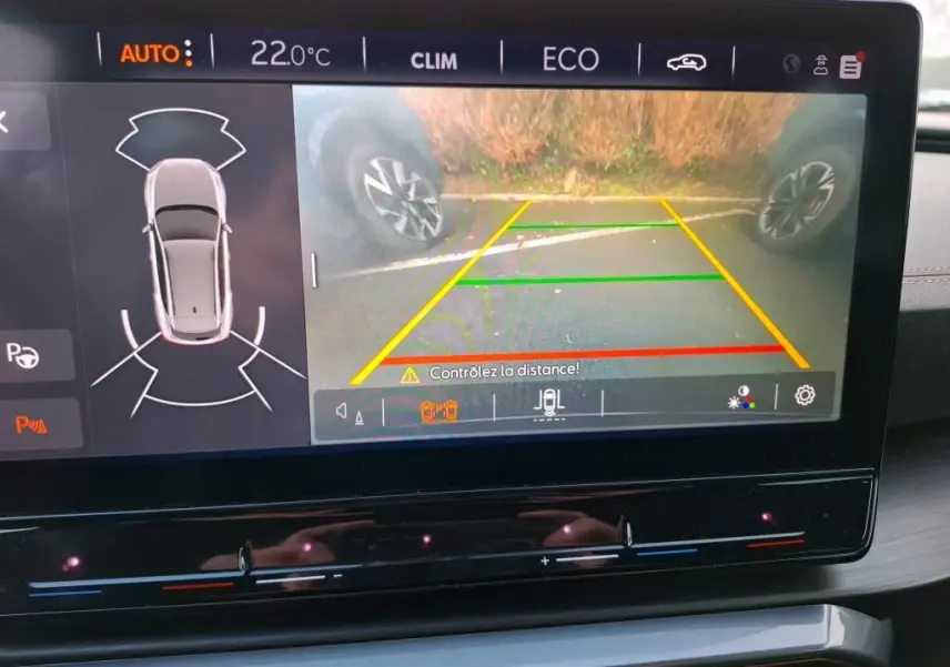 Écran tactile intérieur montrant la caméra de recul et l’aide au stationnement du CUPRA Formentor gris, vue du tableau de bord.