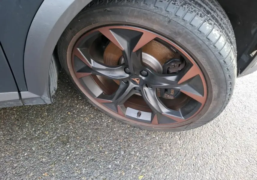 Gros plan sur la jante alliage 19 pouces bicolore noir et cuivre du côté avant droit du CUPRA Formentor gris.