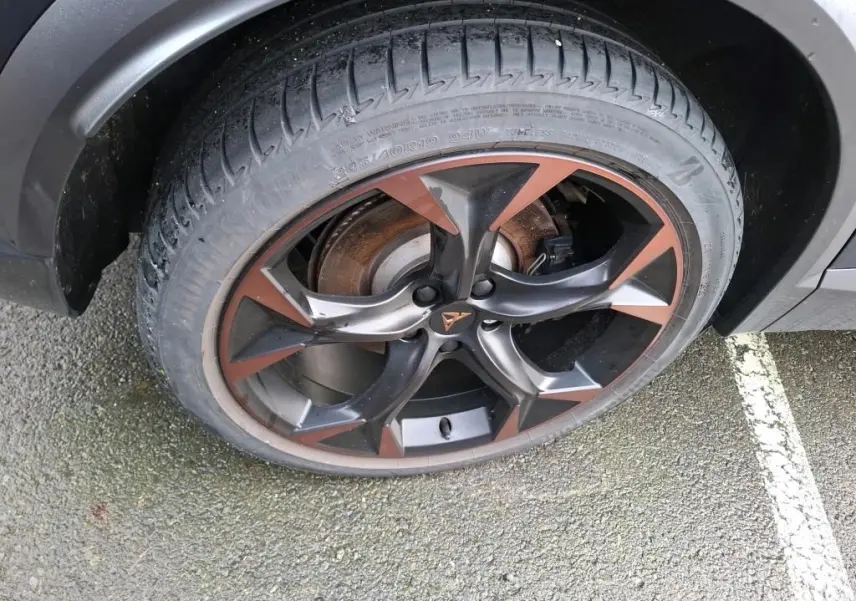 Gros plan sur la jante alliage 19 pouces bicolore noir et copper du côté avant droit du CUPRA Formentor gris.