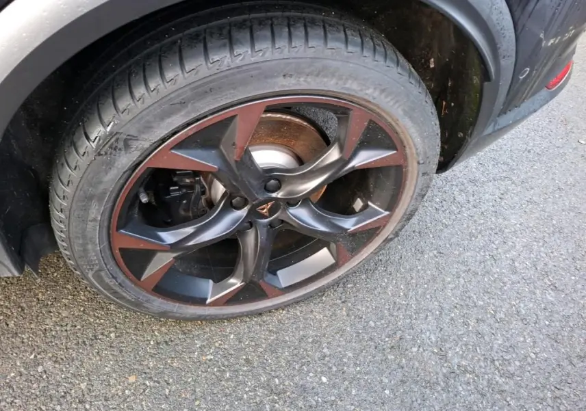 Gros plan sur la jante 19 pouces bicolore noir et cuivre du côté arrière droit du CUPRA Formentor gris.