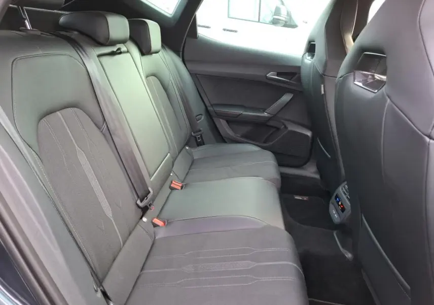 Vue intérieure côté droit des sièges arrière noirs en textile du CUPRA Formentor gris avec surpiqûres et ceintures de sécurité.