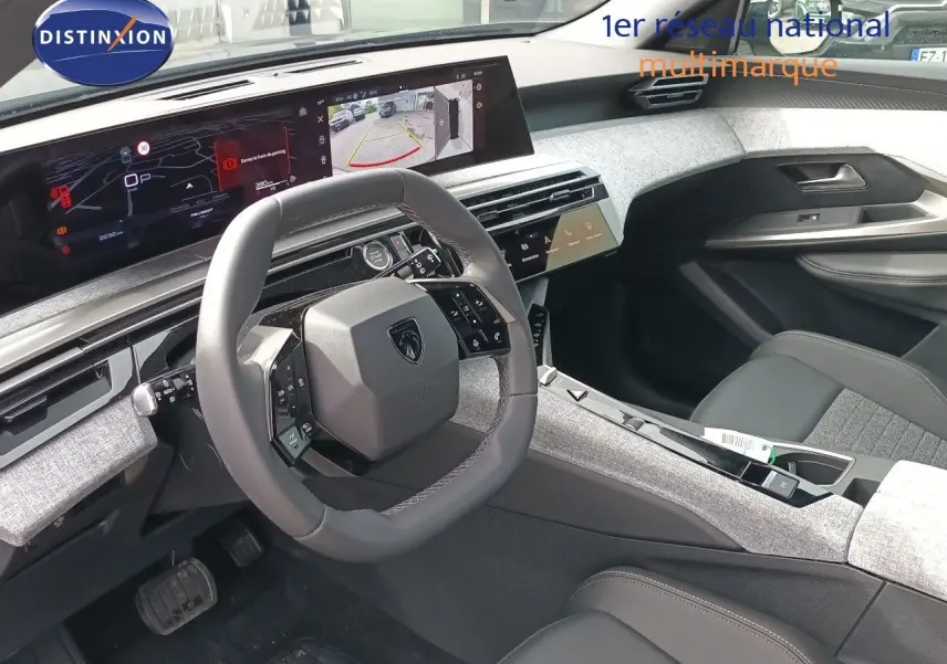 Intérieur du Peugeot 5008 2025 en gris titane, vue côté conducteur sur le volant et l’écran numérique large.