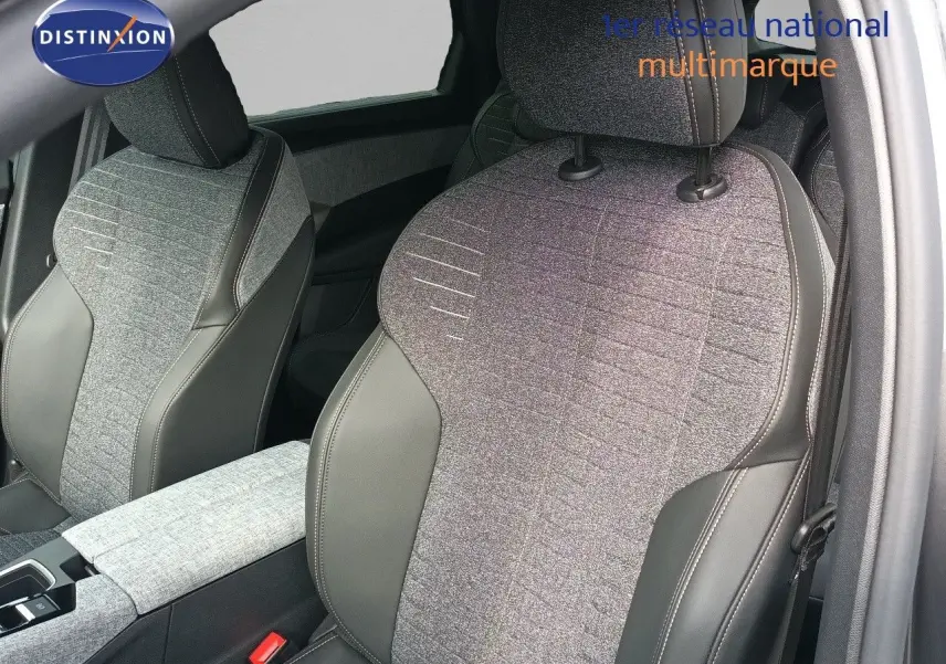 Gros plan sur les sièges avant en tissu gris et cuir noir du Peugeot 5008 1.2 Hybrid 2025, intérieur moderne et soigné.