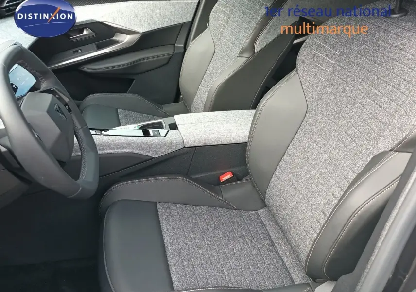Vue intérieure côté conducteur du Peugeot 5008 2025, sièges gris tissu et cuir avec console centrale moderne.